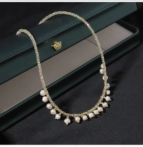 Detail of natural teardrop pearl and faceted crystal necklace in a premium green jewelry box