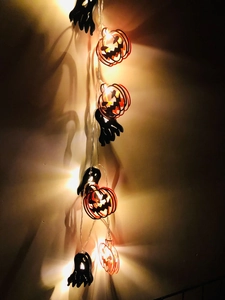 Detail of Halloween LED string lights with orange pumpkins and black bats casting shadows