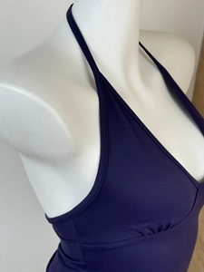 Detail of deep purple halter top showing fine knit texture and adjustable neck ties
