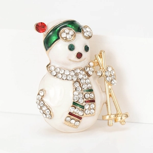 Détail d'une broche bonhomme de neige en émail avec écharpe en strass et lunettes