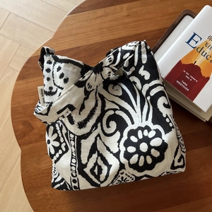 Detail of bohemian linen shoulder bag with abstract black and white print and side label