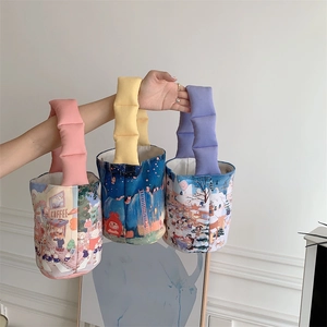 Detailed close-up of quilted handles on cartoon illustration canvas tote bags in three colors