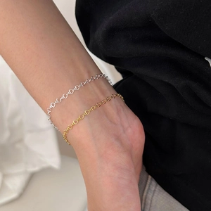 Model wearing both gold and silver minimalist 925 sterling silver heart charm bracelets