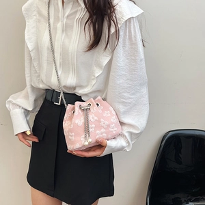 Pink bucket bag with 3D floral texture, drawstring closure, and elegant pearl chain strap