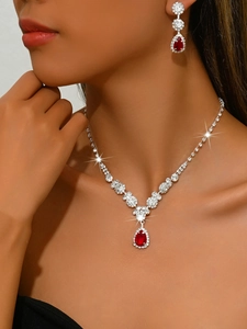 Detail of bridal jewelry set with red pear-cut stones and sparkling crystal accents