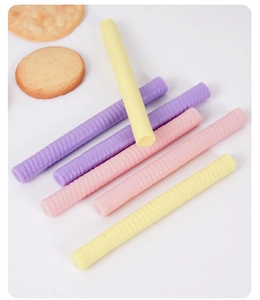 Macro detail of macaron-colored PVC chocolate sticks with spiral texture on white background