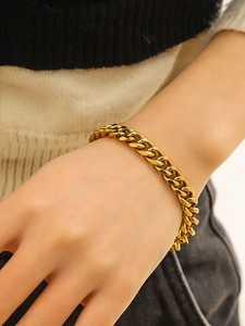 Close-up of a gold-plated stainless steel Cuban link bracelet worn on a male wrist