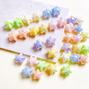 Rainbow gradient star beads for DIY crafts on marble surface, glossy macaron colors
