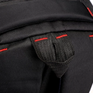 Detail of durable black nylon backpack featuring red reinforced stitching and a webbed loop