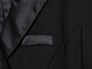 Gros plan d'une veste de smoking avec revers en satin et détails de strass sur la poche