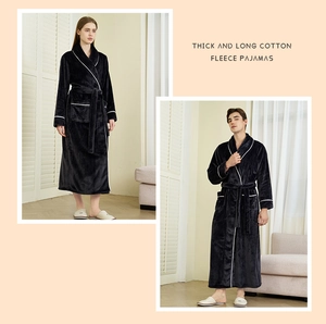 Detail view of thick black flannel bathrobe with white piping and waist belt