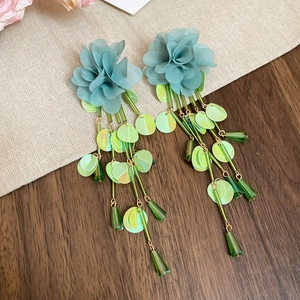 Detail of mint chiffon flower earrings with green iridescent sequins and long tassels
