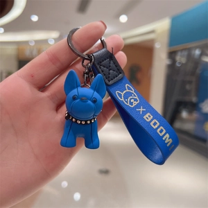Close-up of blue resin French Bulldog keychain with X BOOM leather strap and rivet collar