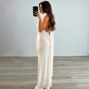 Side view of white backless halter neck maxi dress with slim fit stretch fabric