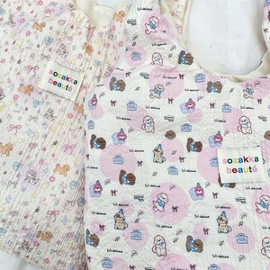 Dettaglio ravvicinato della borsa trapuntata con gatti, pois rosa e tessuto strutturato
