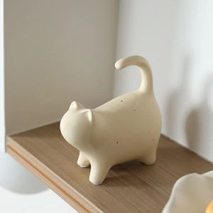 Modern beige ceramic cat figurine with fine black speckles for elegant home desk decoration