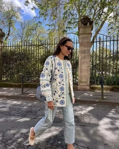 Détail de la broderie florale sur une veste matelassée en coton bleu et blanc ceinturée