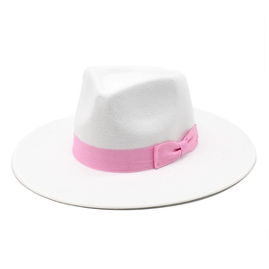 Close-up of white wool fedora hat featuring a stylish pink ribbon and decorative bow detail