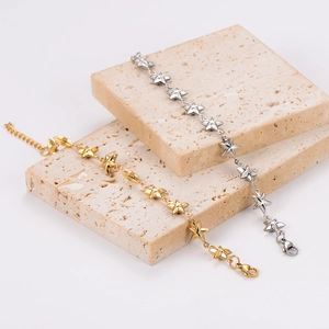 Star-shaped chain bracelets in gold and silver finish on textured stone blocks