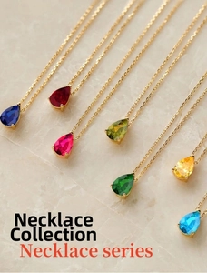 Macro view of pear-shaped gemstone necklaces in various colors on golden fine chains