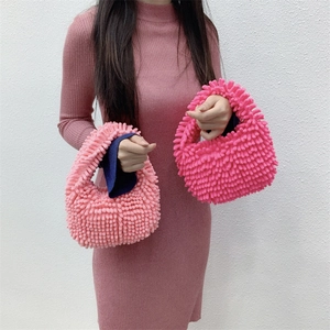 Detail of plush chenille handbags in soft pink and fuchsia colors for autumn winter style
