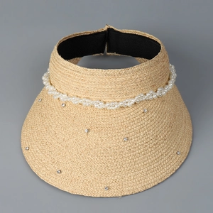 Detail of beige straw sun visor featuring pearl band and rhinestone embellishments