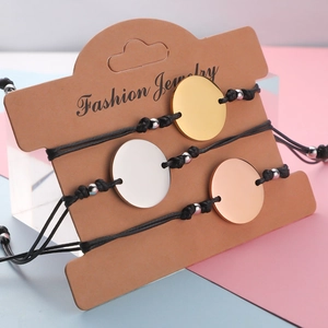 Three-piece set of woven wax cord bracelets with gold, silver, and rose gold metal discs