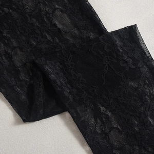 Gros plan sur un tissu en dentelle noire avec des motifs floraux et une texture de maille
