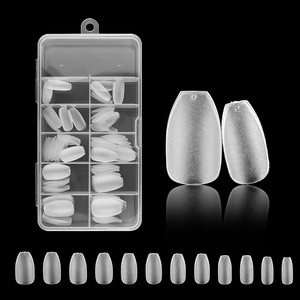 Close-up of clear false nail tips in a storage box with detailed size comparison