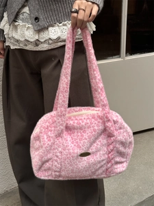 Detailansicht der rosa Plüschtasche mit Leopardenmuster, Metalllogo und Reißverschluss