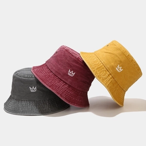 Three crown embroidered washed cotton bucket hats in dark grey, burgundy, and ginger yellow