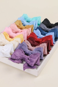 Détail de rubans à froufrous colorés et accessoires cheveux nœuds sur un plateau