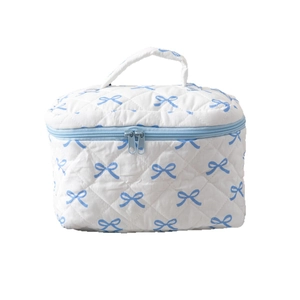Quilted white cotton makeup bag with blue bow prints and top handle for travel