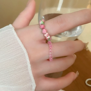 Close-up of pink flower ceramic beads and transparent resin bead elastic rings set