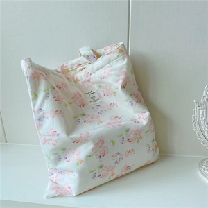 Detailed view of floral canvas tote bag with pink flowers and a vintage cloth label