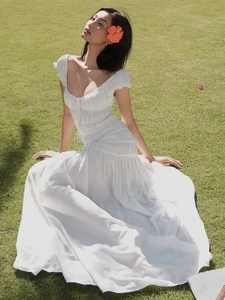 Robe blanche élégante à col en V plissée avec manches lanternes sur fond de pelouse