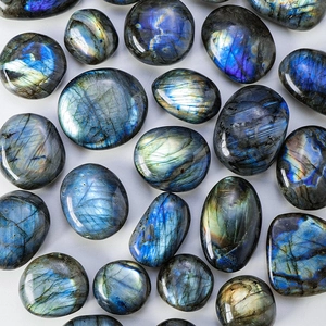 Polished natural labradorite stones with vibrant blue and gold iridescence on light surface