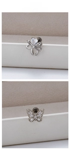 Macro shot of titanium steel butterfly ear studs with zircon heart and wings details