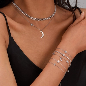 Detail of layered S925 silver necklaces and star-moon bracelets with white zircon