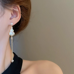 Detailed view of Chinese style tassel earrings with pearl flower and gold gourd pendant