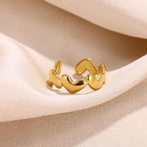 Detailed macro view of 18k gold plated stainless steel heart rings on fabric