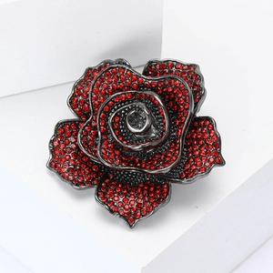Elegant vintage rose flower brooch with red rhinestones on a black metal base