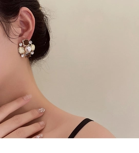 Close-up of vintage floral earrings with pearl center and sparkling crystals on model