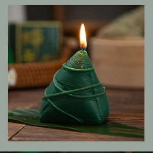 Close-up of green zongzi-shaped scented candle on a rustic wooden table for Dragon Boat Festival