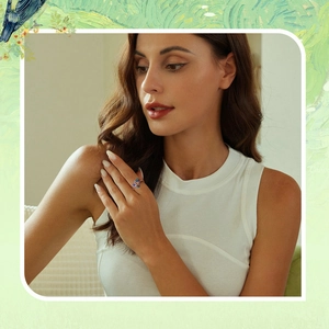 Detail of s925 silver flower ring with blue and purple gemstones worn on a model's finger