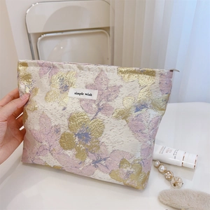 Vue détaillée d'une pochette fleurie en jacquard avec fil doré et étiquette simple wish