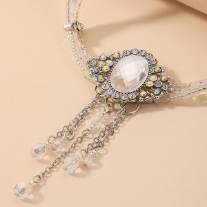 Gros plan détaillé du pendentif baroque en cristal ovale avec accents de diamant et glands
