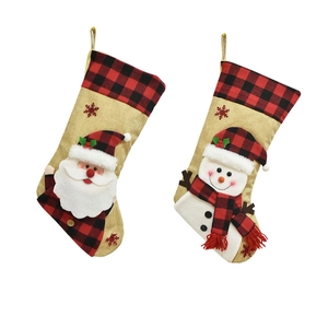 Detail of burlap Christmas stockings featuring Santa, snowman and red buffalo plaid cuff