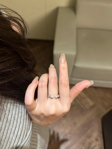 Close-up of a silver twist open ring featuring two pearls on a model's hand