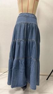Dettaglio della gonna maxi in denim blu con balze a strati e cuciture a patchwork